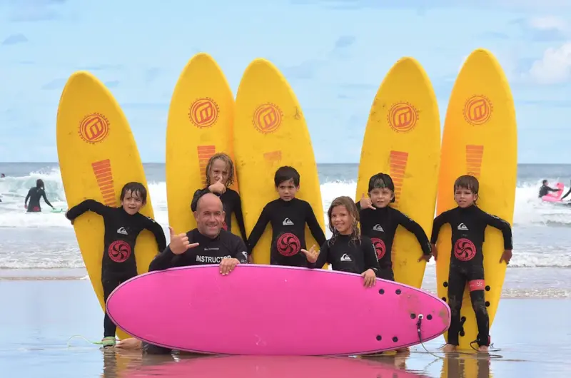 niños y profesor en surfcamp con tablas de surf 