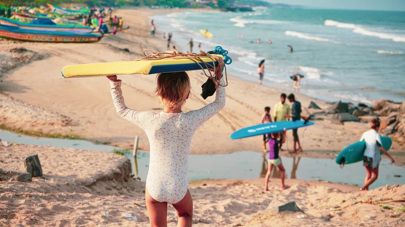 niños con tabla de surf en la playa