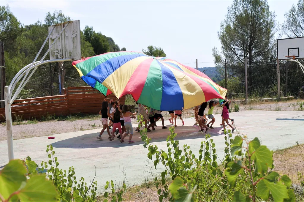 niños jugando con una lona en el campamento de verano de summer camp