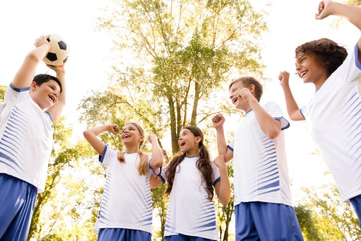 Beneficios del deporte en los niños. Grupo de niños celebrando victoria
