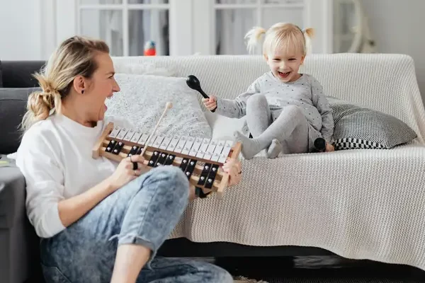 Niña cantando y explorando la música con su madre