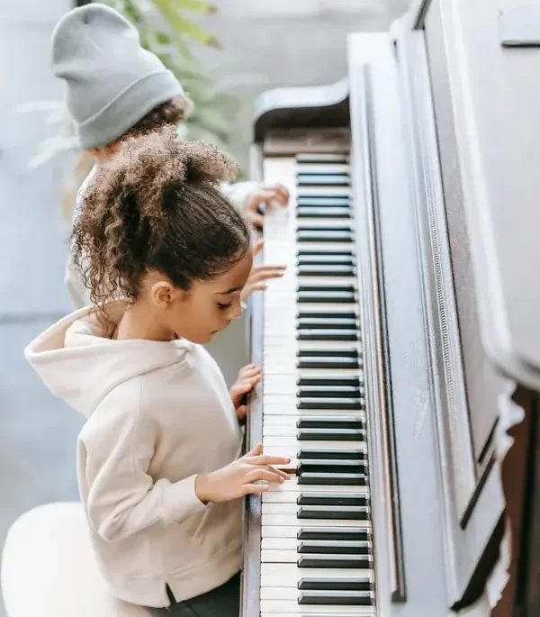Dos niños tocando el piano.