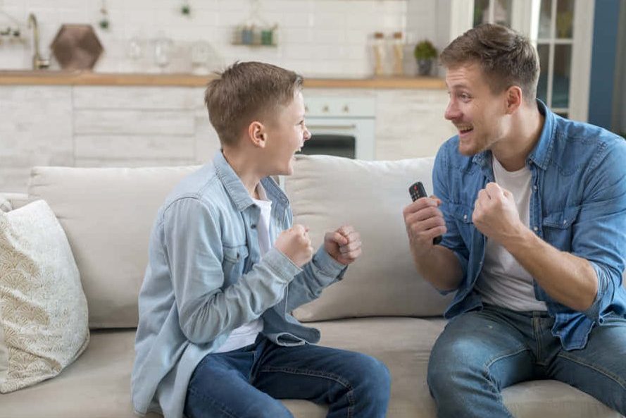 Ansiedad vuelta al cole. Hombre y niño celebrando juntos