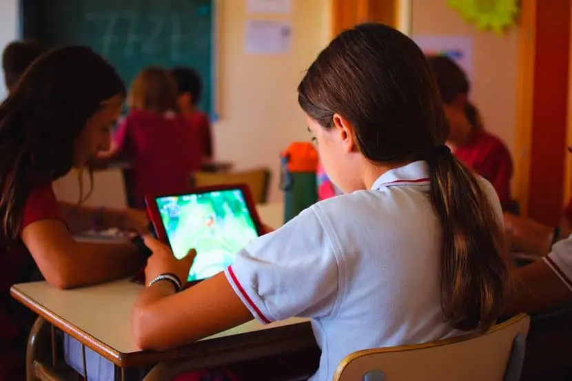 niña con videojuego educativo en clase